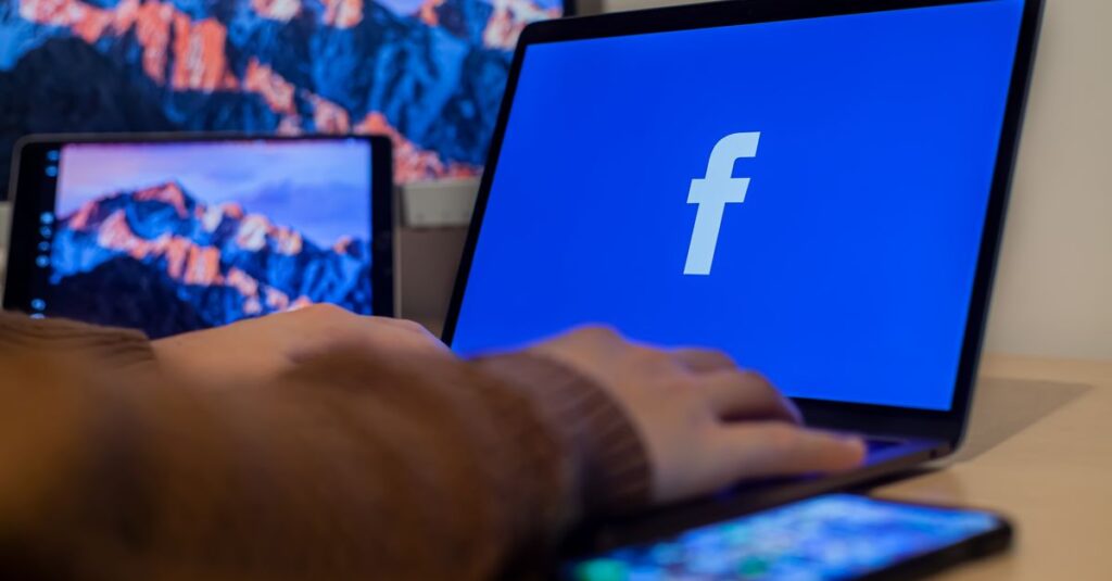 Laptop displaying Facebook at workspace with multiple devices, highlighting modern technology.
